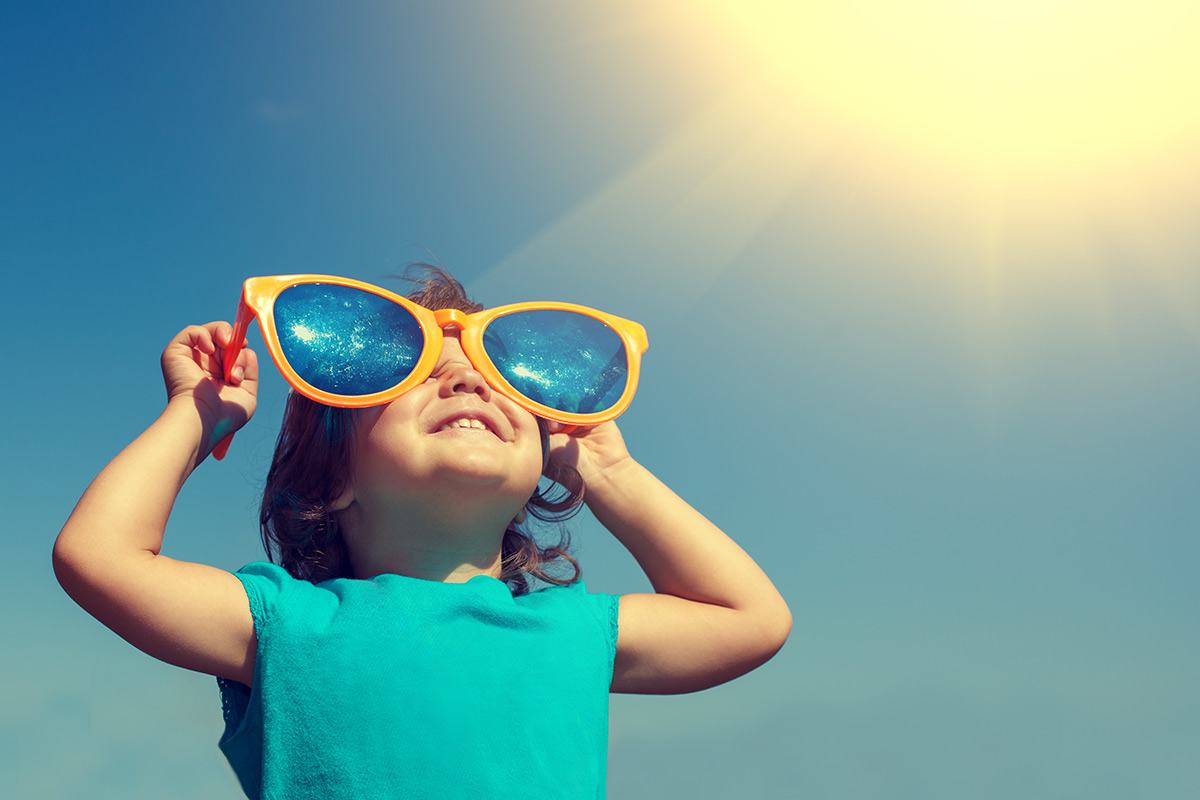 Little girl standing outside wearing large sunglasses