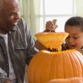 grandfather and grandson opening a pumpkin