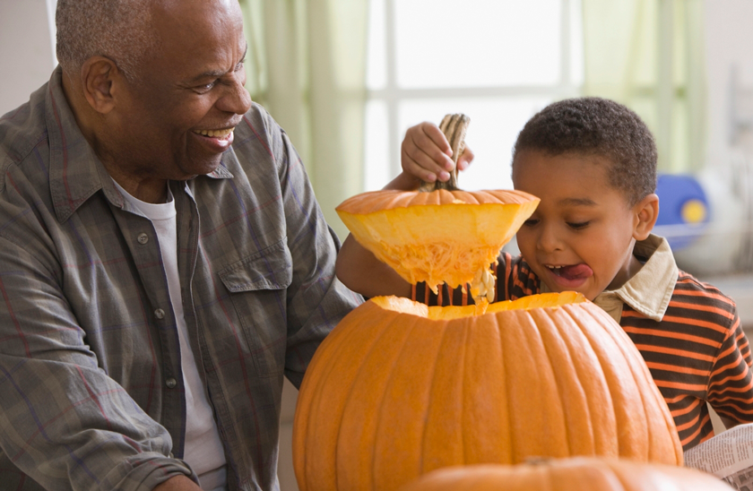 grandfather and grandson opening a pumpkin