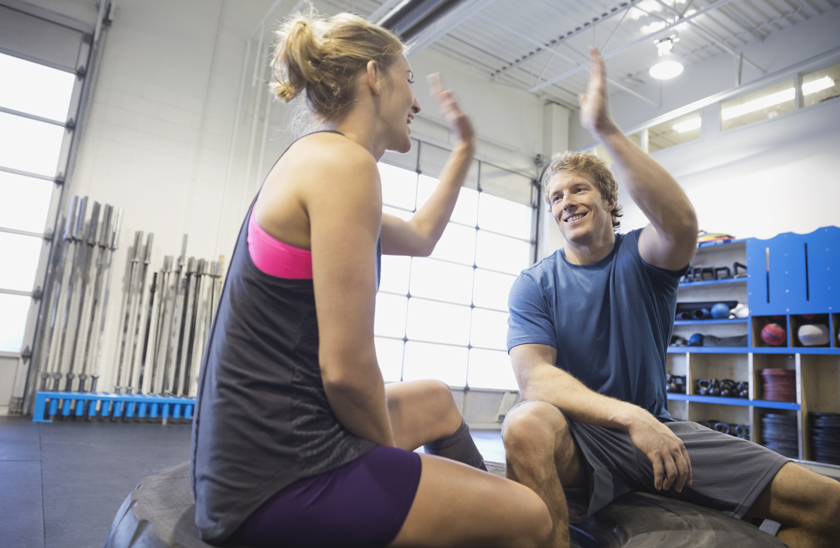 young man and woman high five after their workout