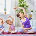 mother doing yoga with her young daughters