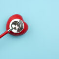 Stethoscope and red heart on blue background