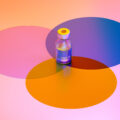 Digital generated image of COVID-19 vaccine bottle standing on multi coloured circles on purple background.