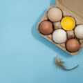 Directly Above Shot Of Eggs In Carton Over Blue Background