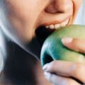 CLOSE UP OF WOMAN EATING AN APPLE