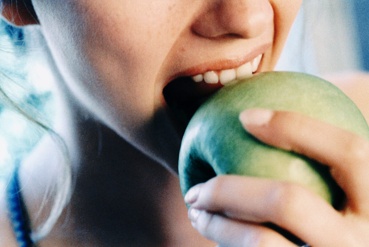 CLOSE UP OF WOMAN EATING AN APPLE