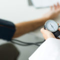 Doctor measuring patient's blood pressure, cropped view