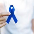 March Colorectal Cancer Awareness month, Woman holding dark Blue Ribbon for supporting people living and illness.
