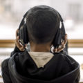 Rear view of autistic boy with headphones at home