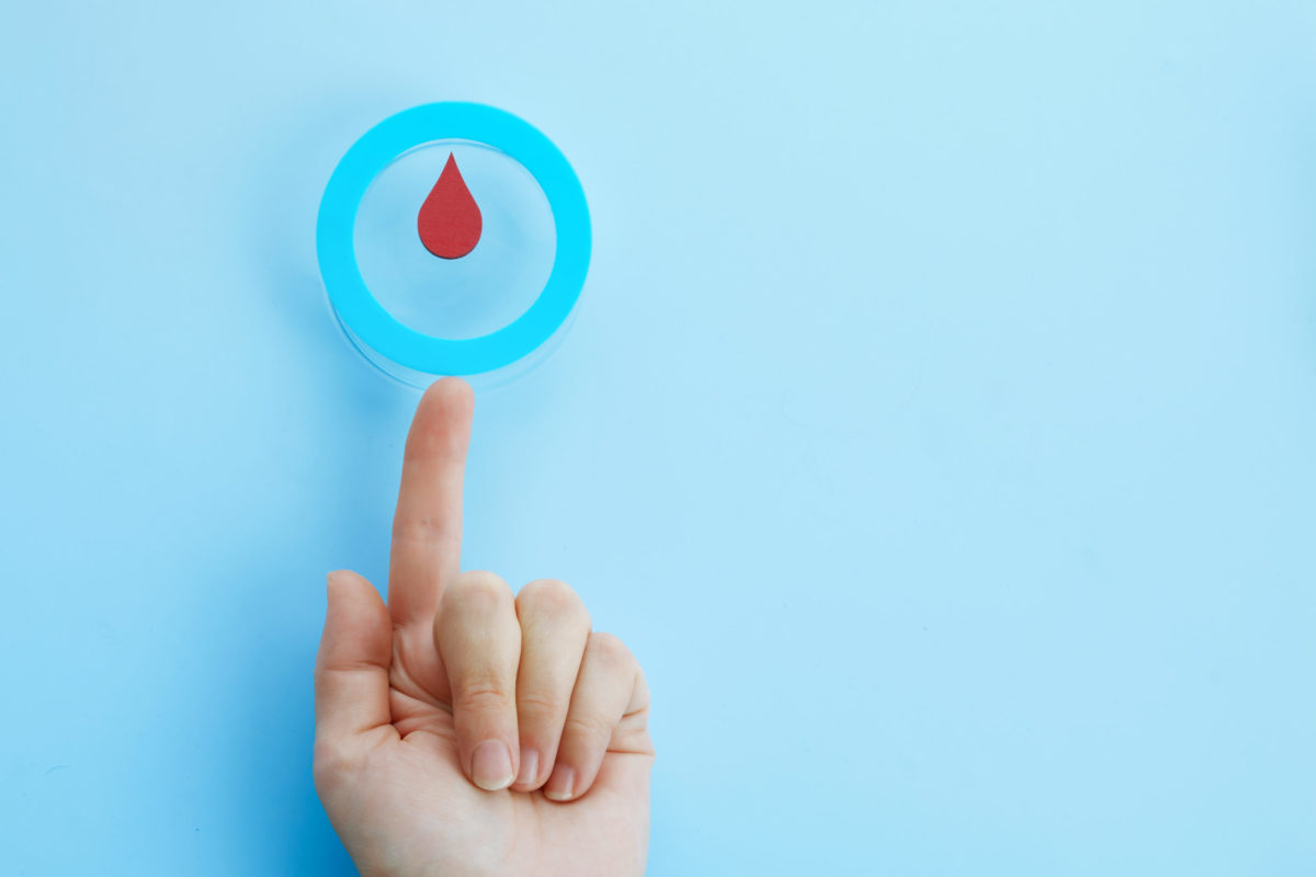 World diabetes day awareness. Woman hand with a blue circle with blood drop, symbol of the diabetes.