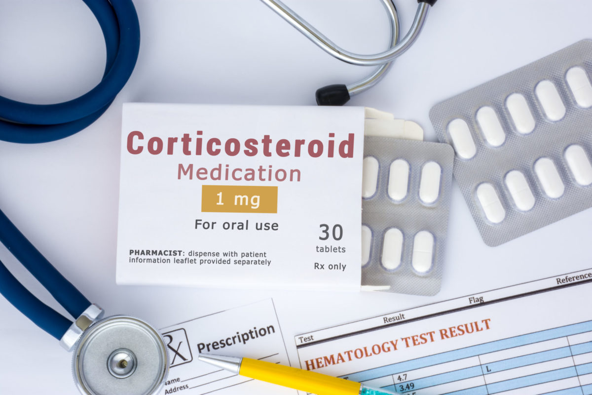 Corticosteroid medication or drug concept photo. On doctor table lies open packaging labeled "Corticosteroid medication" and fell out of blisters with pills treatment