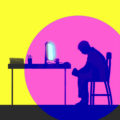 depressed man sitting in front of glowing computer screen.
