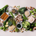 Variety of healthy vegan, plant based protein source and body building food. Tofu soy beans tempeh, green vegetables, nuts, seeds, quinoa oat meal and spirulina. View from above
