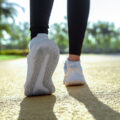 Woman feet running on road closeup on shoe. Young fitness women runner legs ready for run on the road. Sports healthy lifestyle concept
