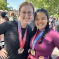 Kendra Satterwhite and her friend Korie posing with medals around their neck after finishing a half marathon