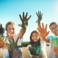 Shot of a group of youth having fun with colourful powder at summer camp