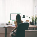 Businesswoman working at home, sitting down at a desk, about to stand up