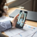 Businesswoman having telehealth visit with doctor on a mobile phone