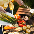 Woman cooking vegetables on barbecue grill outdoors, closeup