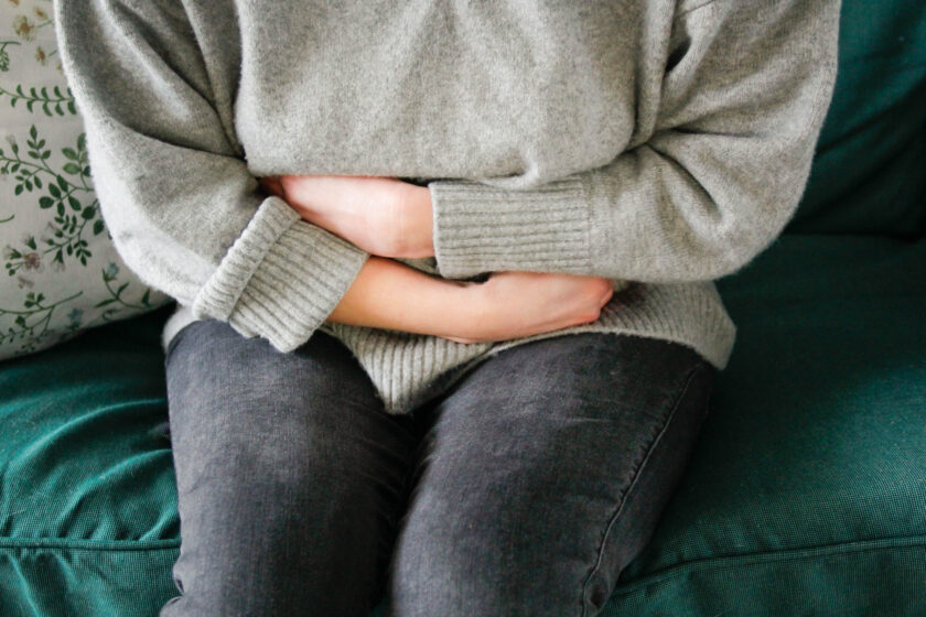 person holding their stomach as if it hurts