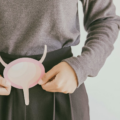female holding paper cutout representing a bladder in front of her abdomen