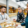 A group of people sitting down and eating lunch together.