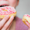 Person eating doughnuts