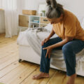 woman holding leg, possibly in pain.