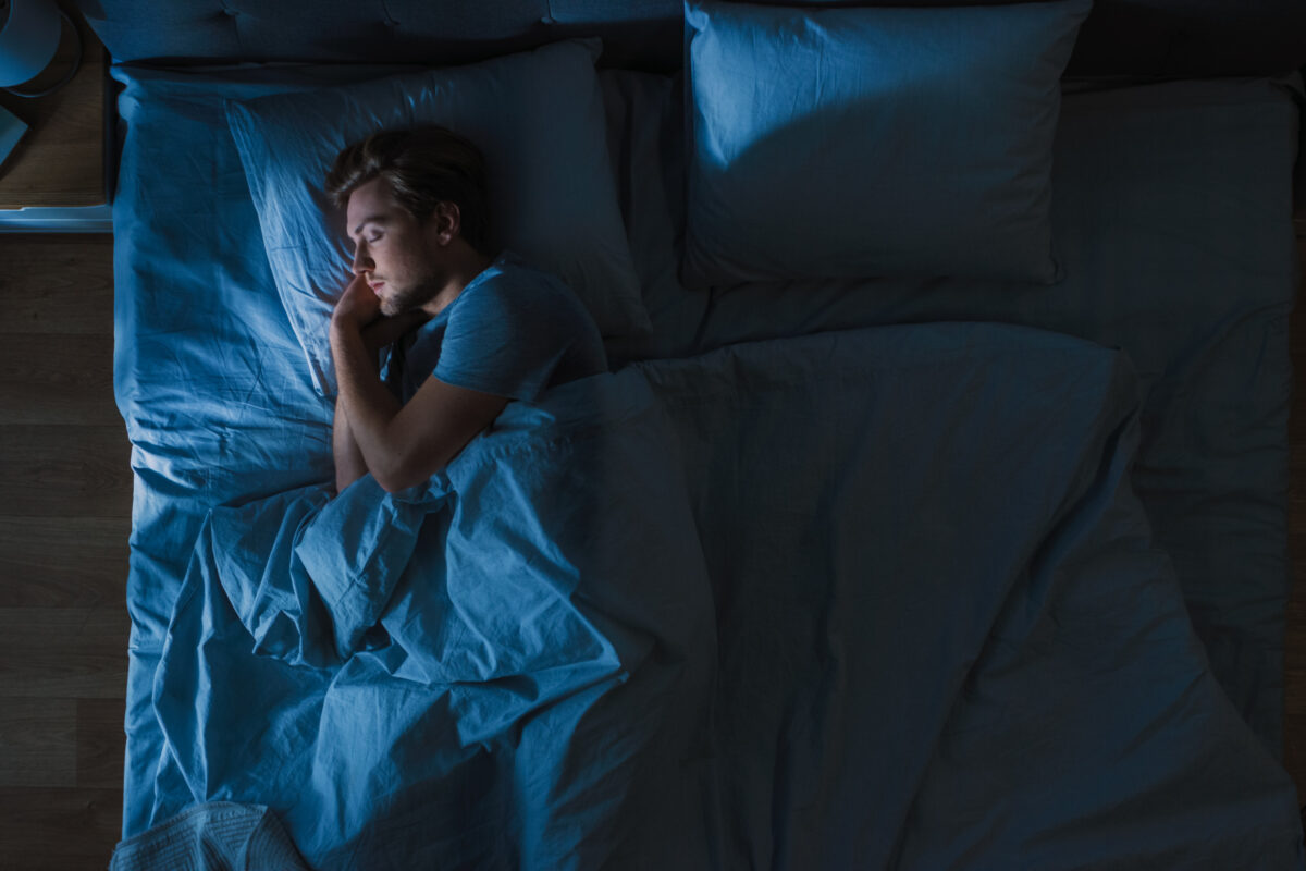 Person asleep in bed at night.