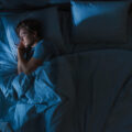 Person asleep in bed at night.