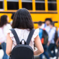 Rear view of girl walking to school bus
