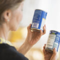 woman reading labels on canned food