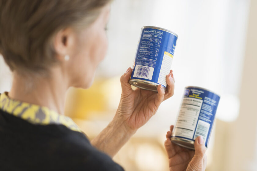 woman reading labels on canned food