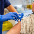 Hands of an unrecognizable nurse injecting the flu vaccine.