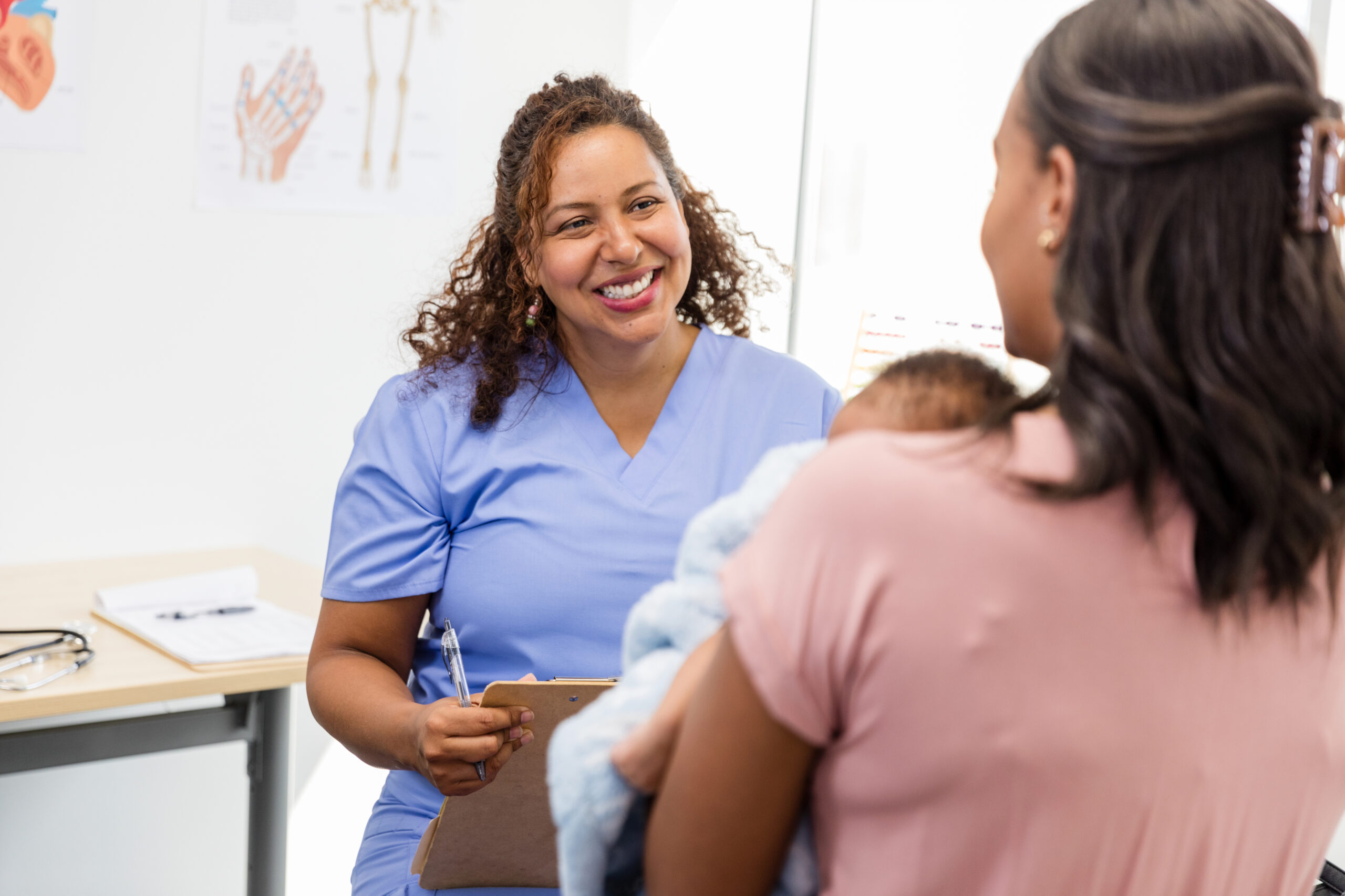 Doctor Talking with Patient and Baby in Medical Clinic