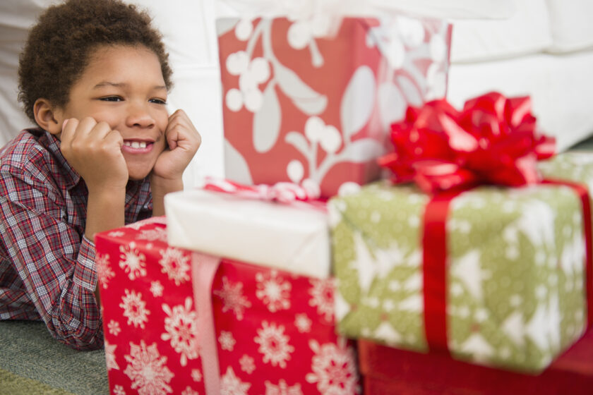 Young boy gazing at wrapped presents.