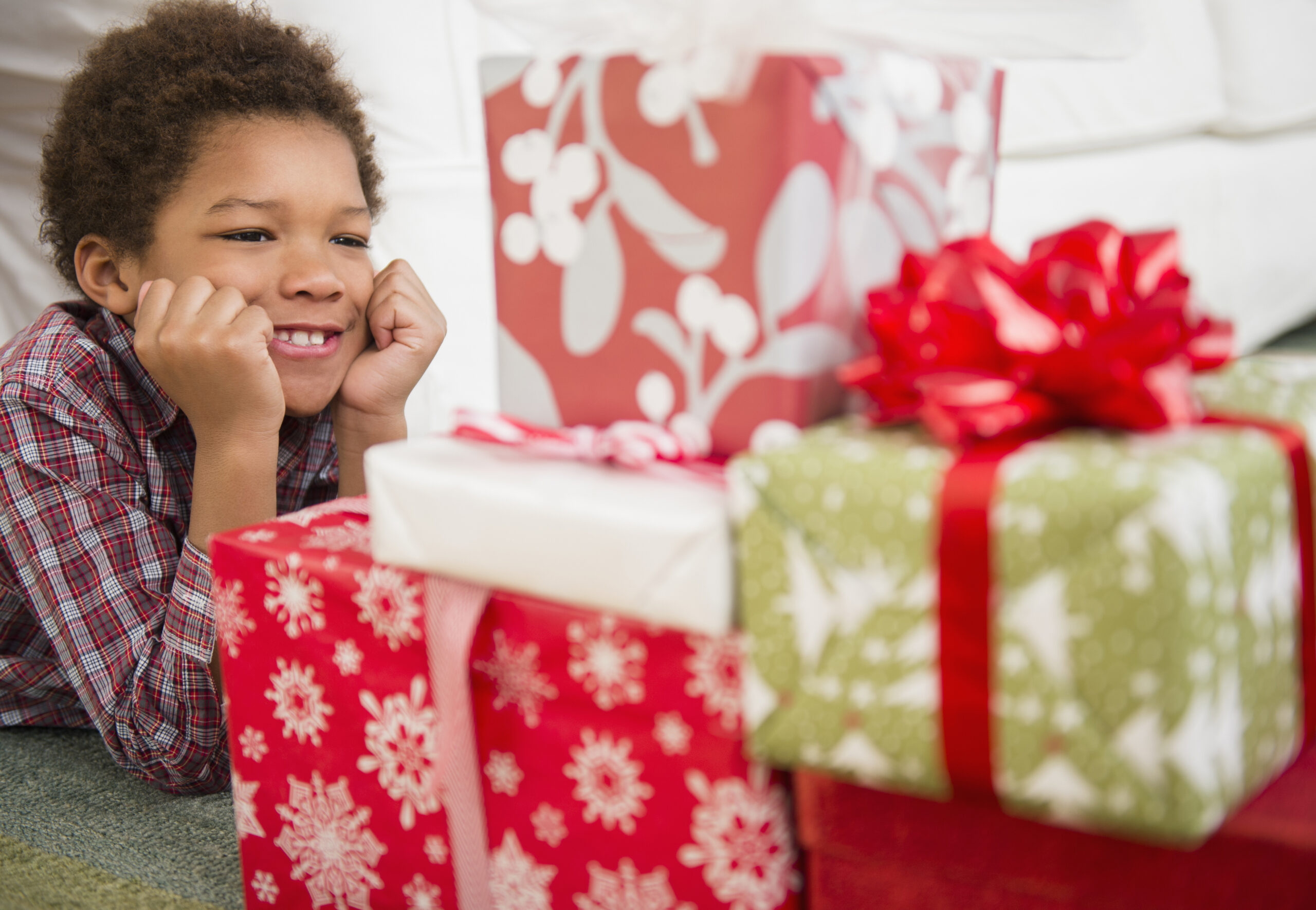 Young boy gazing at wrapped presents.