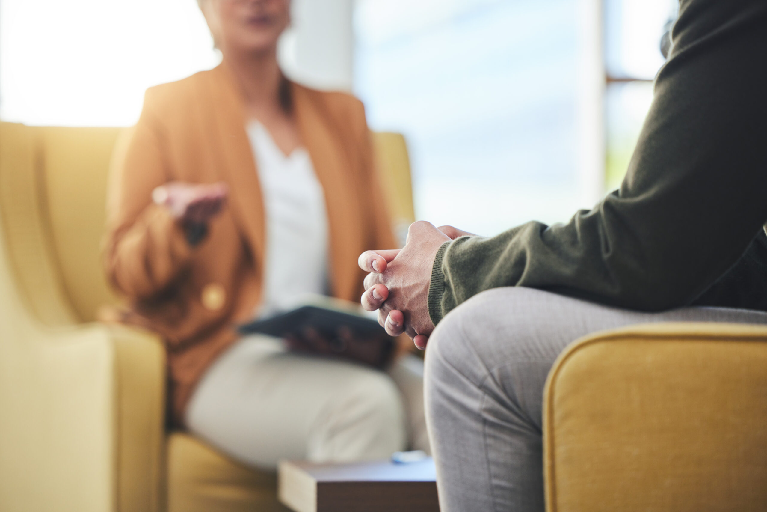 Photo of man, hands and listening for therapy, sofa or advice from woman for mental health care.