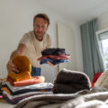 man in his bedroom trying to declutter his home