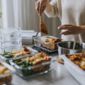 Woman weighing lunch boxes as part of healthy meal prep