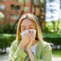 Young Woman Sneezing Due to Spring Allergies