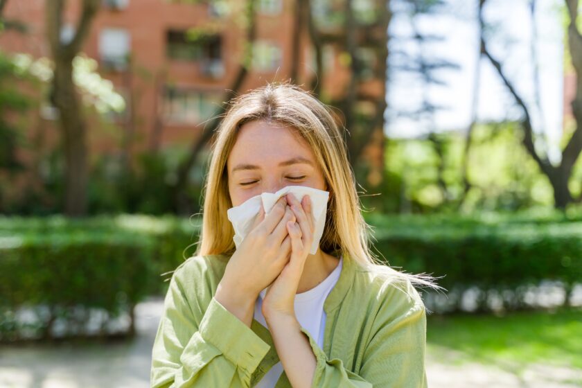 Young Woman Sneezing Due to Spring Allergies