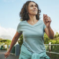 Mature woman in sportswear smiling while out for a power walk