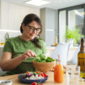Mature woman eating healthy fresh vegetables meal. Dieting and wellbeing concept