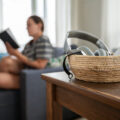 Woman reading book while smartphone is in a basket