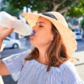 Young woman drinking a bottle of water on a sunny day