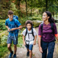 A family of three out walking a woodland trail together.