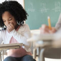 Student writing in classroom