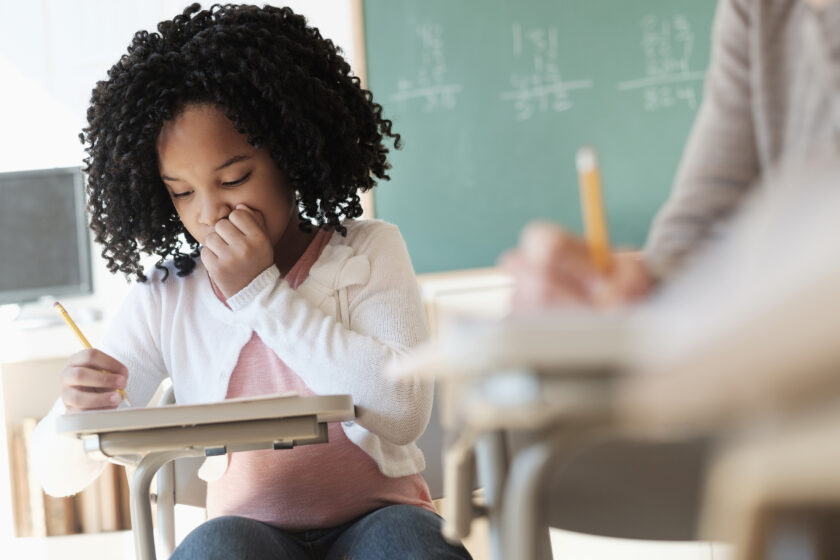 Student writing in classroom