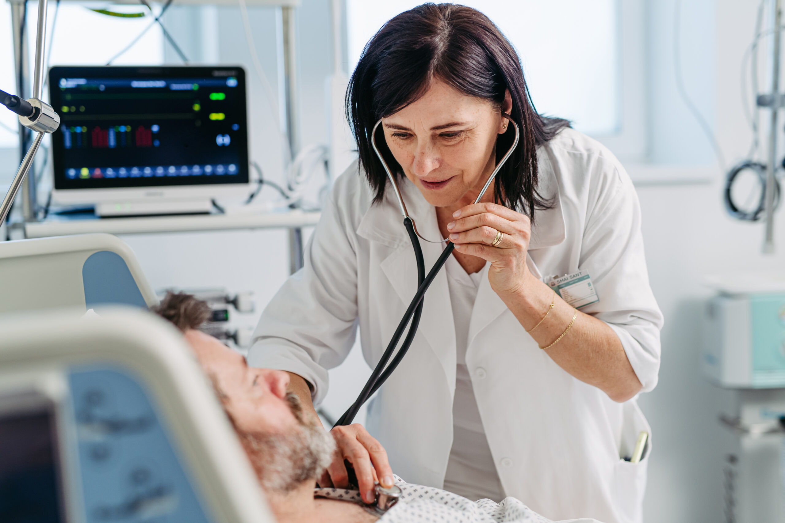 Doctor listening to patient's heart and breathing with stethoscope.